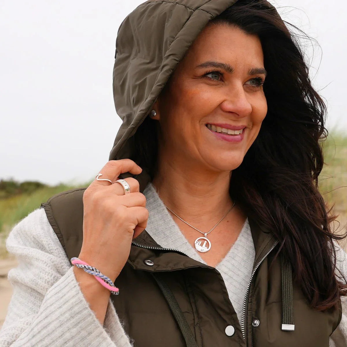 Frau mit rosa-blauem Armband Korallenriff am Handgelenk am Strand, maritimer Schmuck