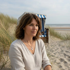 Frau mit silberner Ankerkette am Strand vor Strandkorb, maritimer Schmuck, Küste