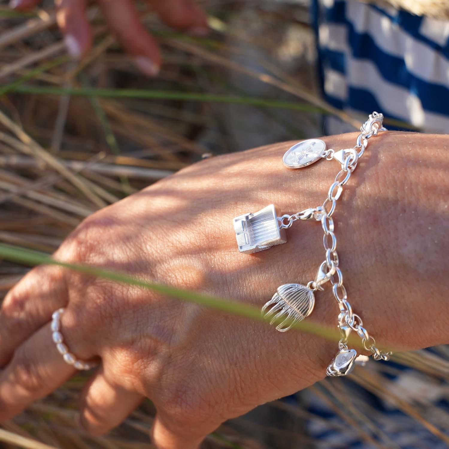 Silber-Armband mit maritimen Charms wie Strandkorb, Qualle und Muschel am Handgelenk