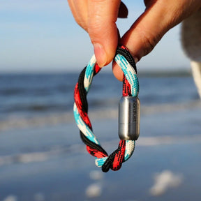 Geflochtenes maritimes Armband in Rot, Schwarz und Blau mit Magnetverschluss am Strand
