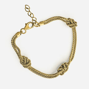 Goldenes Armband mit drei Wellenknoten, maritimer Schmuck auf weißem Hintergrund