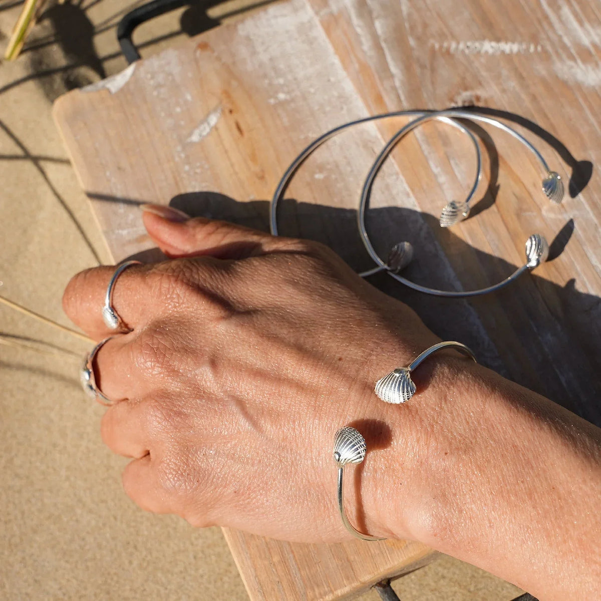 Silberner Armreif mit Muschel-Design, maritimer Schmuck, am Handgelenk getragen