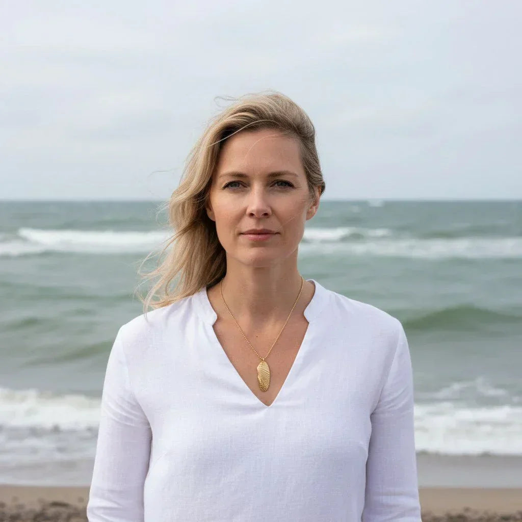 Frau am Strand mit goldener Muschelkette, maritimer Schmuck, Küstenstil