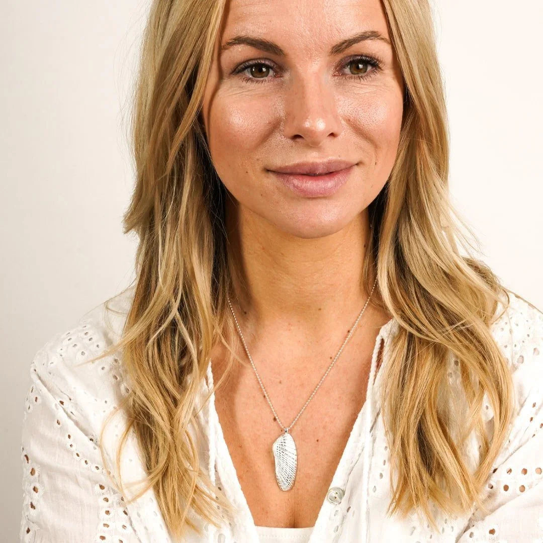 Frau trägt maritimen Anhänger in Muschelform aus Silber an Kette, Strand Schmuck Look