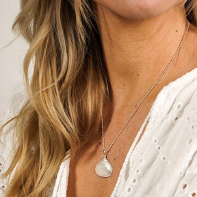 Silberne Muschelkette, maritimer Schmuck, getragen von Frau mit weißer Bluse