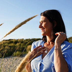 Frau am Strand trägt silberne Muschel-Kette, maritimer Schmuck, Sommer, Natur