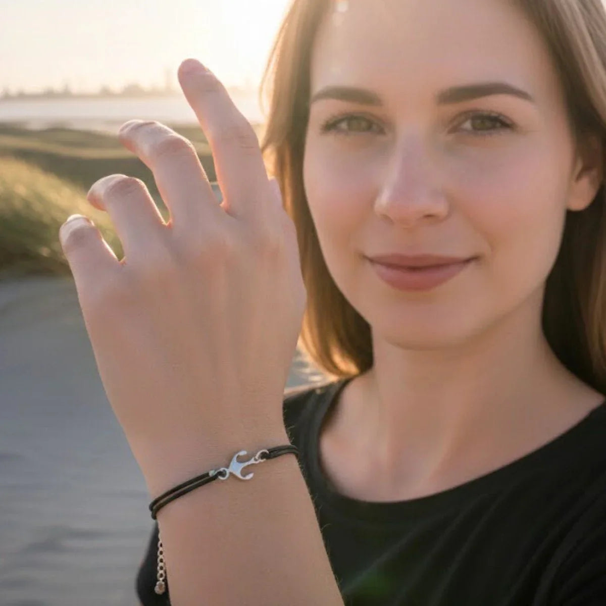 Frau am Strand mit maritimem Lederarmband und silbernem Anker-Anhänger