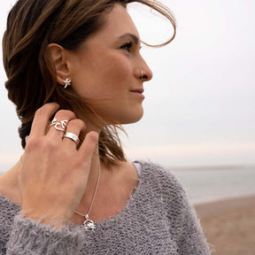 Frau mit silbernen Seestern Ohrsteckern am Strand, maritimer Schmuck, Nahaufnahme