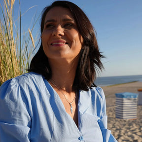 Frau am Strand mit Ringelmuschel-Anhänger aus Silber, maritimer Schmuck, sommerliche Stimmung
