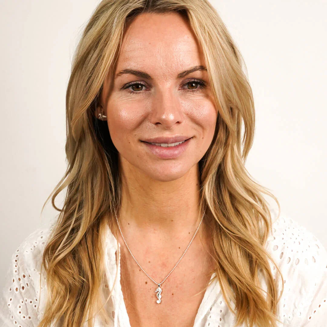 Frau mit silberner Seepferdchen-Kette, maritimer Schmuck, sommerlicher Stil