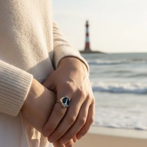 Silberner Siegelring mit Leuchtturm-Motiv am Strand, maritimer Schmuck