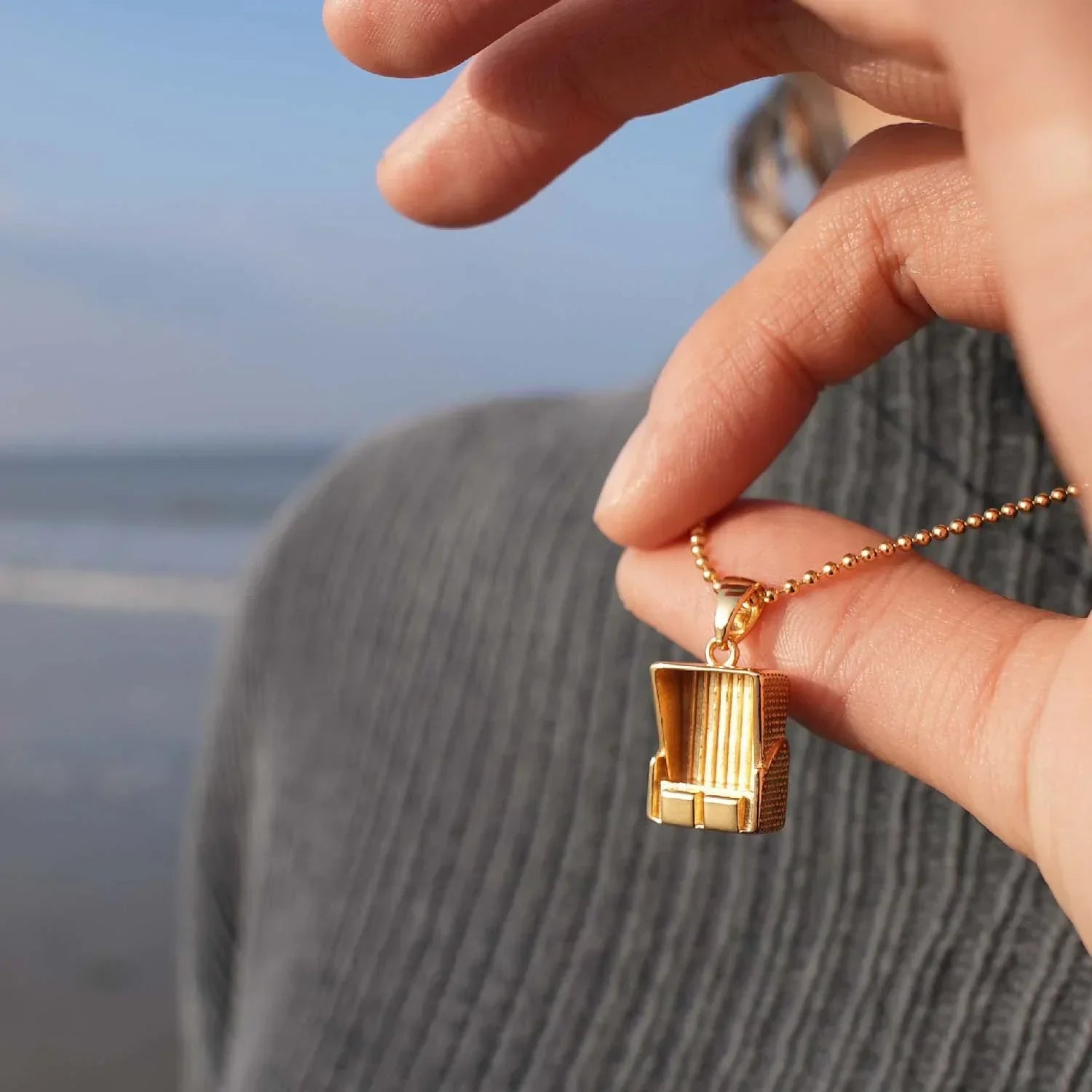 Goldene Kette mit Strandkorb-Anhänger am Meer, maritimer Schmuck für Küstenliebhaber
